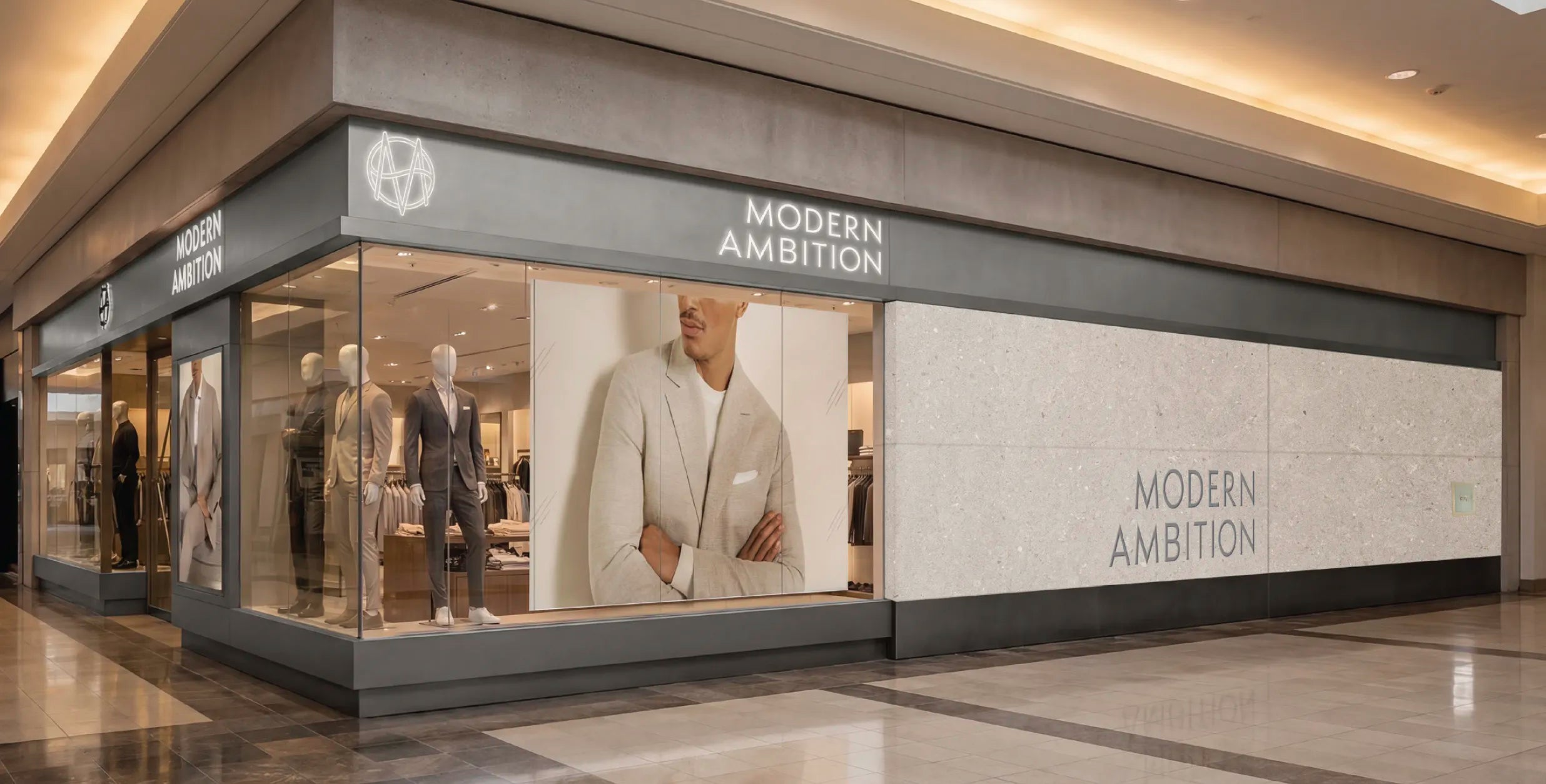 Inside a shopping mall, a corner storefront with 'Modern Ambition' displaying on both sides of the fascia, as well as a large marbled slab taking half of one side, the rest is large display windows with posters, mannequins, and a doorway.
