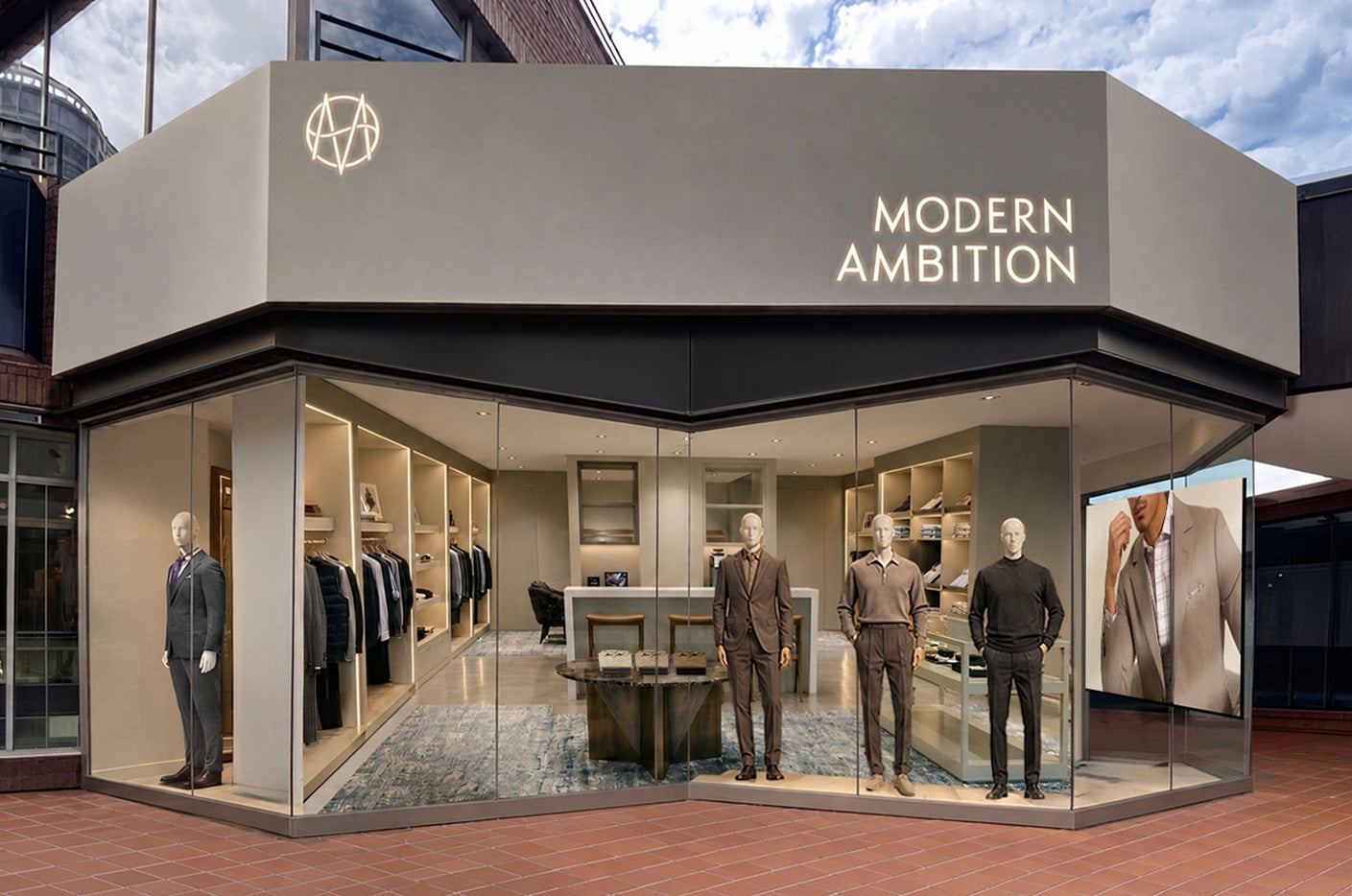 Storefront showing a three-sided tall cement fascia displaying glowing 'Modern Ambition' signage, and v shaped display window with mannequins showing the store interior.